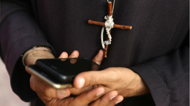 Sacerdote con teléfono móvil