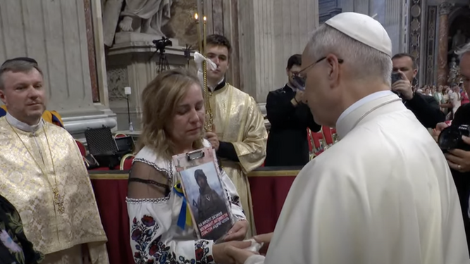Prevost, con una madre ucraniana sosteniendo el retrato de su hijo