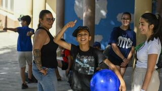 Un niño beneficiario del programa CaixaProinfancia sonríe  sujetando una pelota