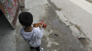 Un niño recibe comida en un comedor de Buenos Aires