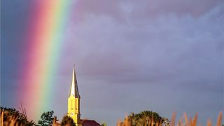 Una iglesia con un arcoíris