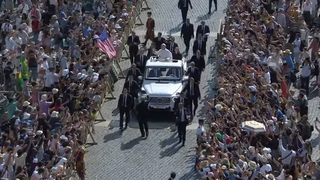 El Papa pasa ante una bandera de su país natal