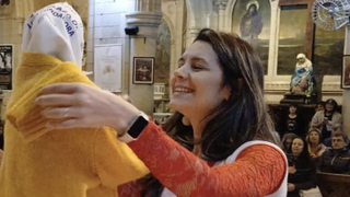 La imagen de la Virgen con el saquito amarrillo y el pañuelo.