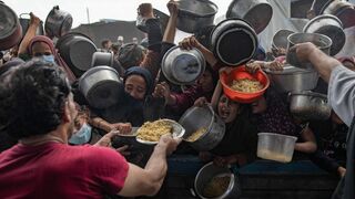Palestinos desplazados se reúnen para recibir alimentos en Khan Younis, en el sur de Gaz