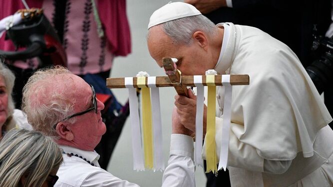 El Papa besa un crucifijo que le presenta en el Jubileo de los romaníes, sinti y caminantes