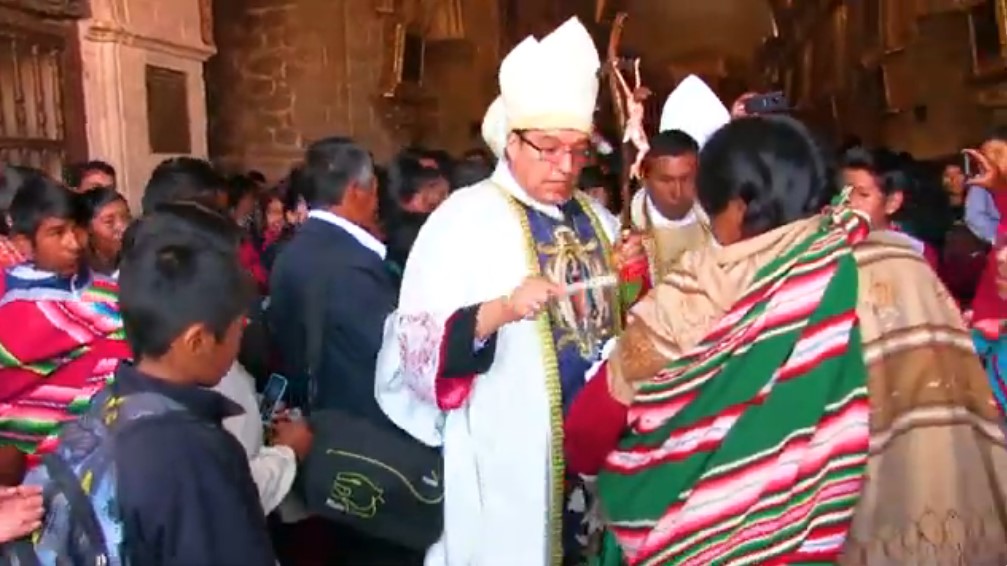 monseñor Quispe Lopez bendice el hijo de una madre indigena
