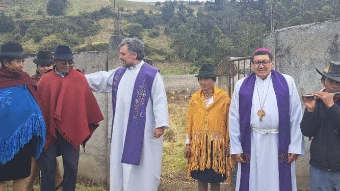 Geovanni y un sacerdote con fieles