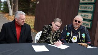 La hermana Sue Ernster firma la venta ante el jefe tribal (derecha)