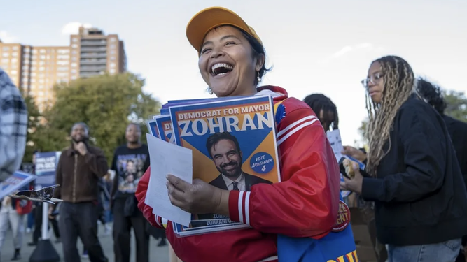 Una mujer reparte propaganda de Zohran Mamdani