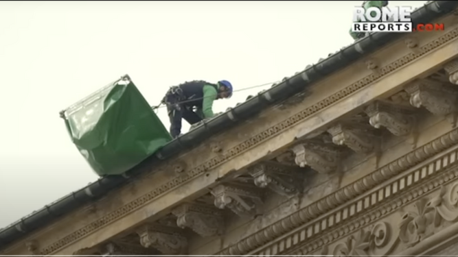 Unos operarios trabajan en el tejado del Palacio Apostólico